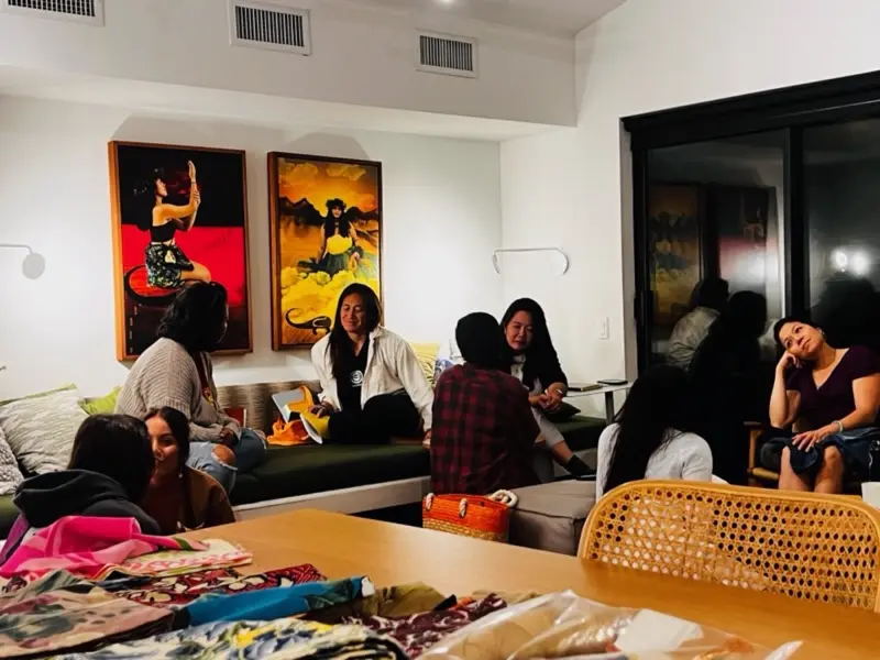 Women gathered around a table in a business workshop.