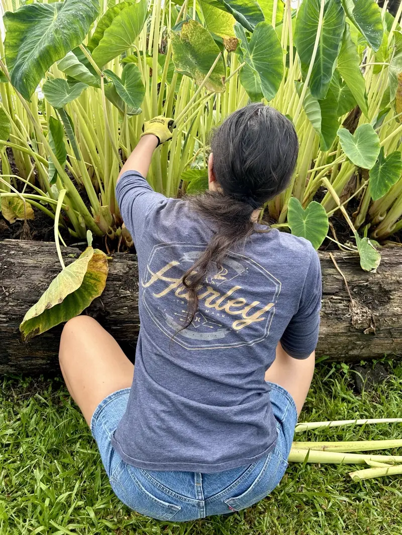 A community member tends young plants during a service day.
