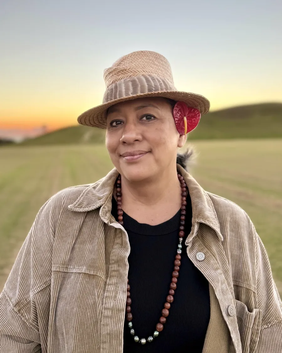Misty Carter, founder of Wahine Wellness Resilient Hawaiʻi, in a field at sunset.